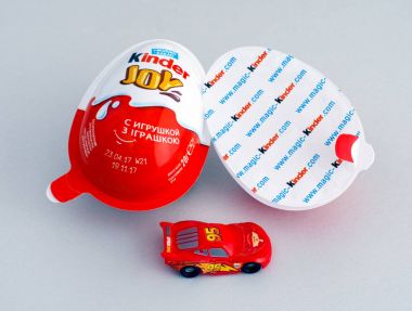 Gri arka plan üzerinde oyuncak araba Kinder kinder sevinç yumurta