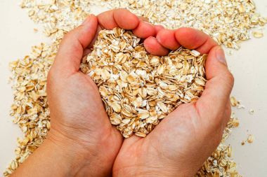 Oats shaping heart in woman hands clipart