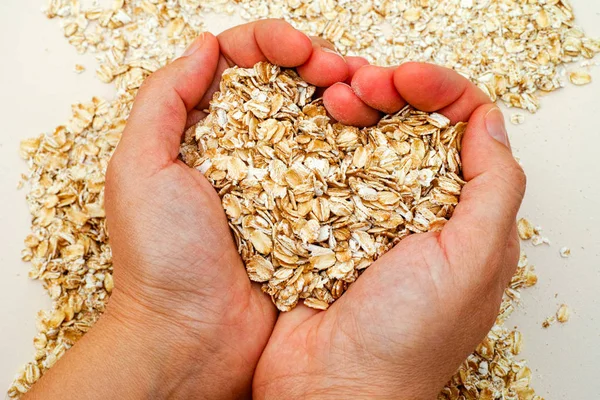 Oats shaping heart in woman hands — Stock Photo, Image