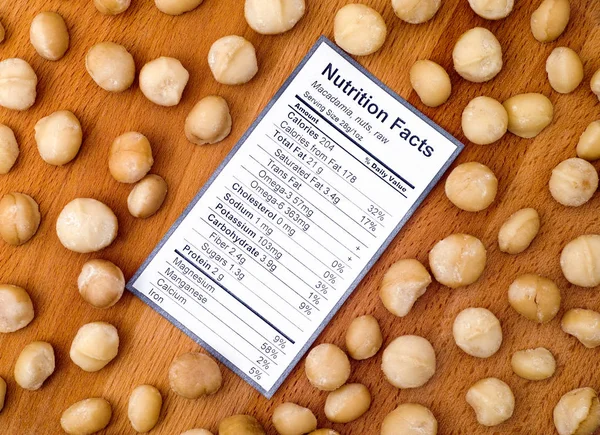 Nutrition facts of raw macadamia nuts with nuts — Stock Photo, Image