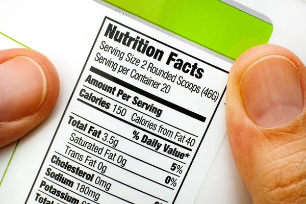 Reading nutrition facts on protein jar. — Stock Photo, Image