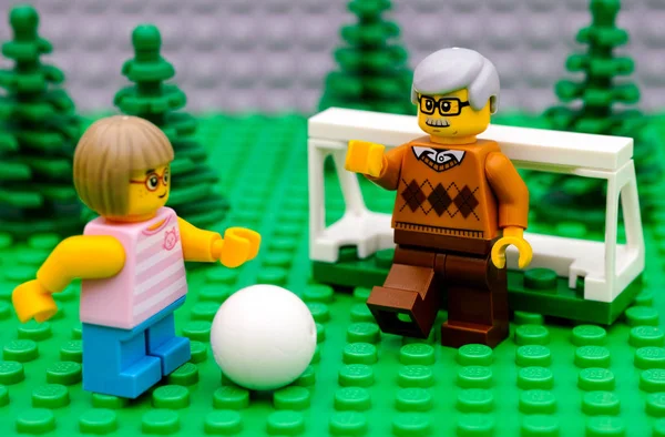 LEGO dívka hrát fotbal se svým dědečkem. — Stock fotografie