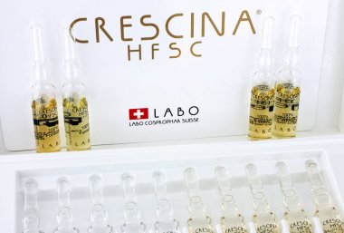 Ampoules of Crescina HFSC Re-Growth in  Crescina treatment box. clipart