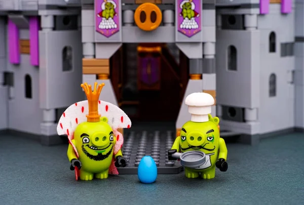 Lego ο βασιλιάς των χοίρων, γουρούνι σεφ με τηγάνι και μπλε αυγό στέκεται κοντά στο κάστρο του βασιλιά χοίρων — Φωτογραφία Αρχείου