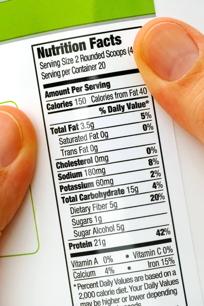 Reading nutrition facts on protein jar. — Stock Photo, Image