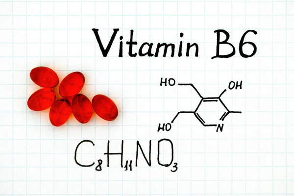 Chemical formula of Vitamin B6 with red pills. — Stock Photo, Image