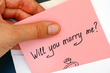 Woman hand taking out letter with text Will you marry me? from e clipart