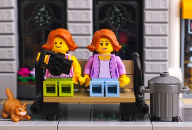 Kırmızı kedi ile Lego sokakta bankta oturma iki Lego kız.