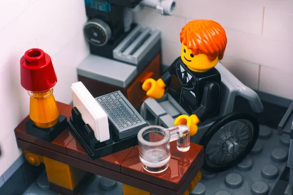 Lego employé de bureau en fauteuil roulant sur son lieu de travail . — Photo