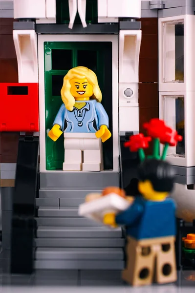 Lego chica en el porche encuentro hombre con flores y regalo . — Foto de Stock