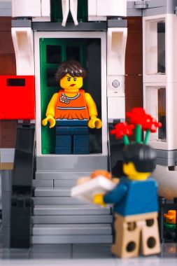 Lego angry girl on the porch looking at man with flowers and gif clipart