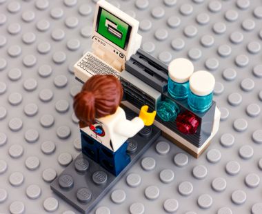 Lego bilim adamı onun çalışma alanı gri baseplate bilgisayarına