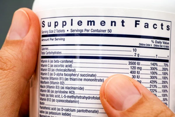 Close-up of white plastic jar with supplement facts of multivita — Stock Photo, Image