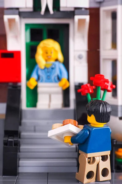 LEGO muž s květinami a dárky jde k dívce. — Stock fotografie