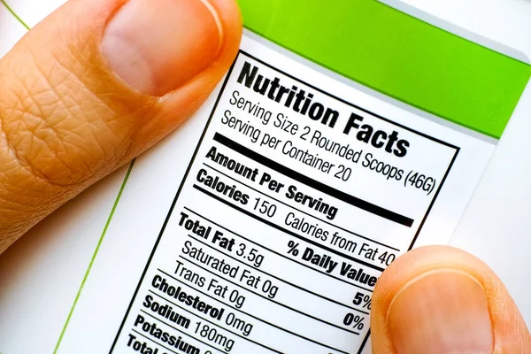Odczyt wartości odżywcze na słoiku białka. — Zdjęcie stockowe
