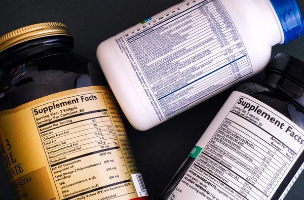 Drie flessen van voedingssupplement met aanvulling feiten labels — Stockfoto