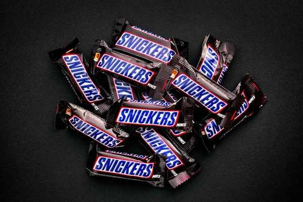 Heap of Snickers minis chocolate bares no fundo preto . — Fotografia de Stock