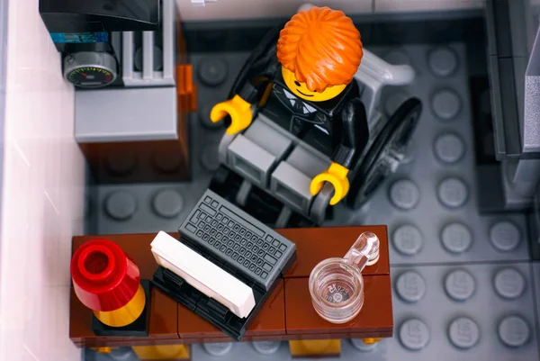 Лего офисный работник в инвалидной коляске на своем рабочем месте . — стоковое фото