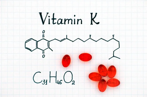 Kémiai képlet, a K-Vitamin és a piros pirula. — Stock Fotó