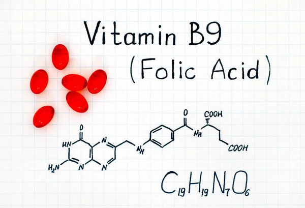 Chemische formule van vitamine B9 (foliumzuur) met rode pillen. — Stockfoto