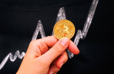 Kadın el altın Bitcoin sanal para blackboar karşı tutarak
