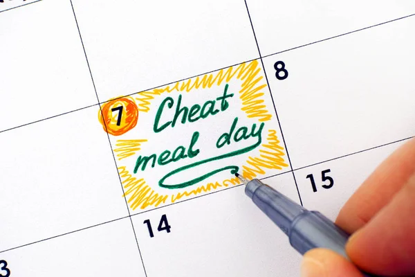 Mulher mão com caneta escrevendo lembrete Cheat Meal Day no calendário — Fotografia de Stock
