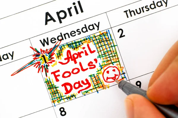 Woman fingers with pen writing reminder April Fools Day in calen — Stock Photo, Image