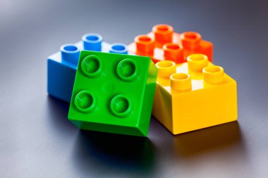 Gri arka plan üzerinde renkli plastik oyuncak yapı taşları