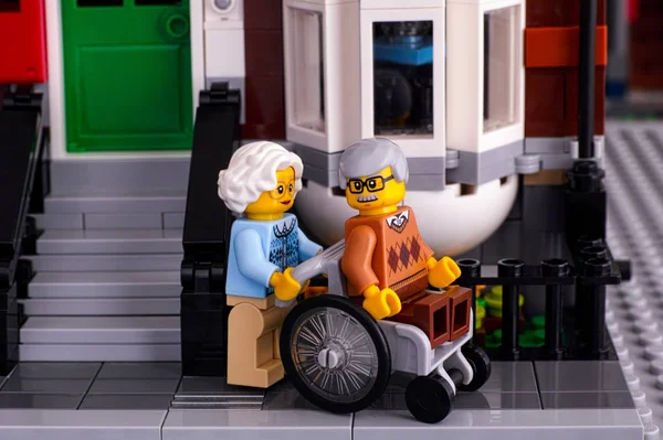 LEGO starszy para w pobliżu jego domu. Człowiek siedzi w wózku, wom — Zdjęcie stockowe