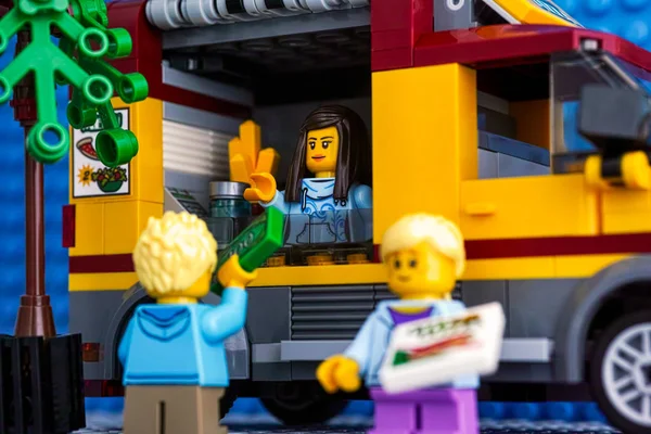 Lego City Pizzawagen mit Verkäufer drinnen und zwei jungen Kunden. — Stockfoto