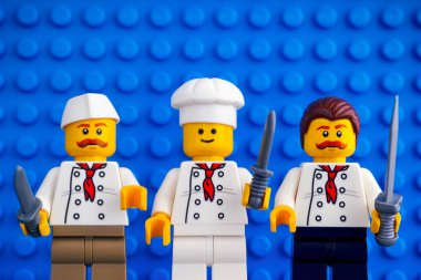 Üç Lego şefler mavi baseplate arka planlar önünde bıçaklı.
