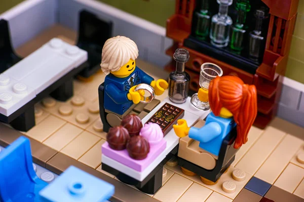 LEGO para siedzi przy stole w restauracji. Człowiek dostaje gotowy t — Zdjęcie stockowe