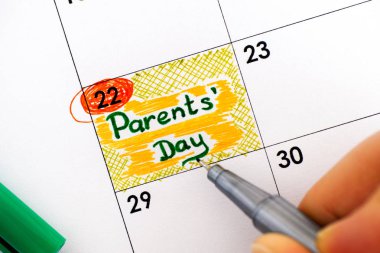 Kadın parmakları ile hatırlatma anne gün takvim içinde yazma kalemi.