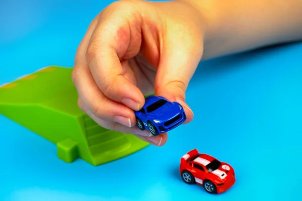 Nano hız mikro otomobiller ile mavi arka plan üzerinde oynayan çocuk. — Stok fotoğraf