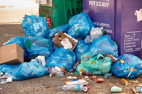 Velké hromady odpadků s pytle na odpadky v blízkosti koše kontejnery. — Stock fotografie