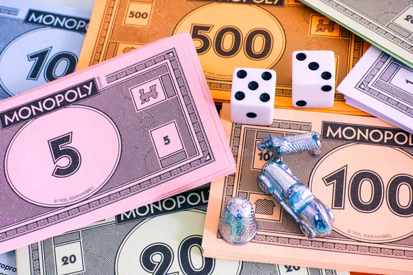 Monopol pakiety pieniądze z tokenów i kości. — Zdjęcie stockowe