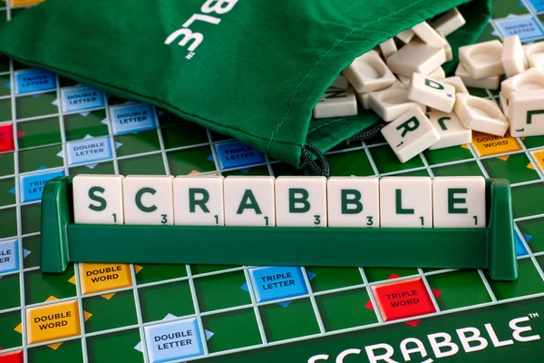 Palabra Scrabble de azulejos de la letra en estante de azulejos en el tablero de juego — Foto de Stock