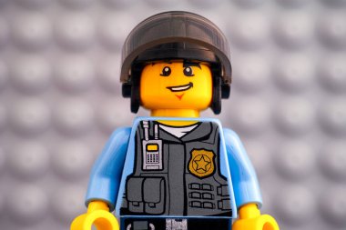 Lego polisinin portresi gri tabaka çantasına karşı miniminnacık.