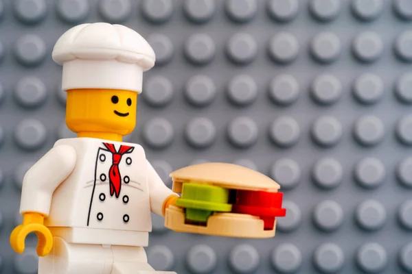 Lego şefi hamburgerli mini figürlü gri tabaka arka planda — Stok fotoğraf