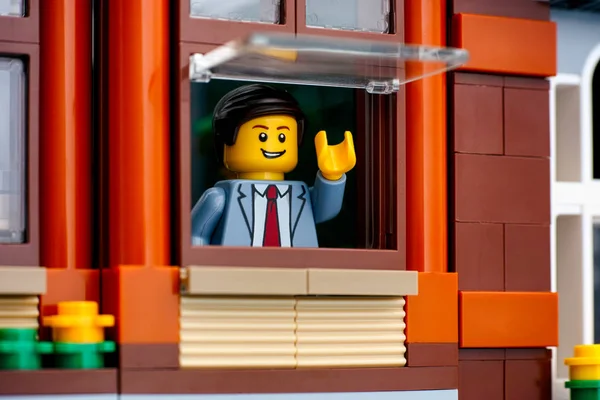 Lego człowiek w garniturze biznesowym patrząc przez okno. — Zdjęcie stockowe