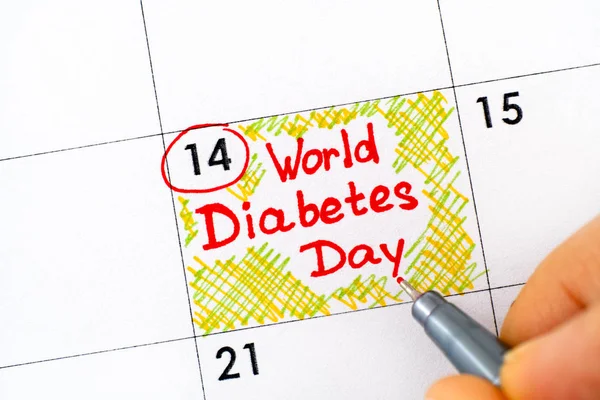 Dedos de mulher com caneta escrevendo lembrete Dia Mundial do Diabetes em ca — Fotografia de Stock