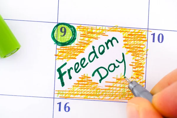 Vrouw vingers met groene pen schrijven herinnering Vrijheidsdag in cal — Stockfoto