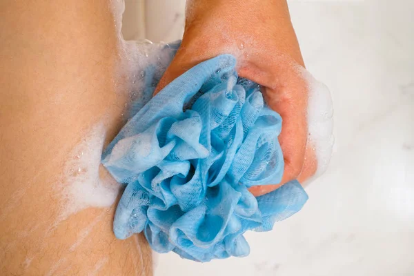 Mulher mão com esponja azul lavar seu corpo . — Fotografia de Stock