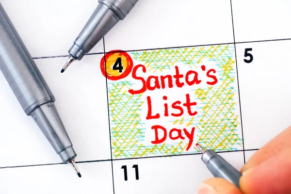 Vrouw vingers met per schrijven herinnering Santas Lijst Dag in schalen — Stockfoto