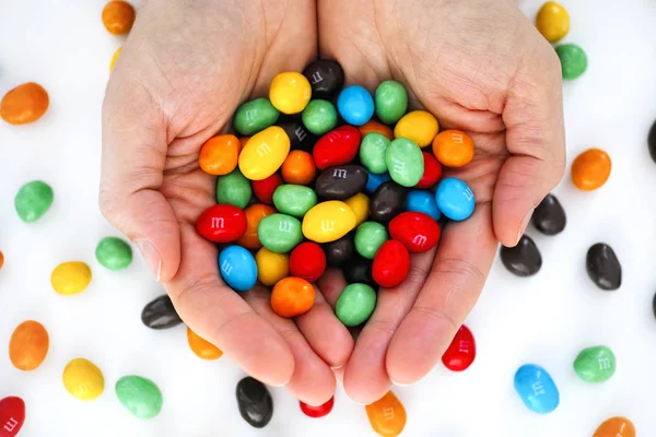 M & Ms doces em mãos de mulher . — Fotografia de Stock