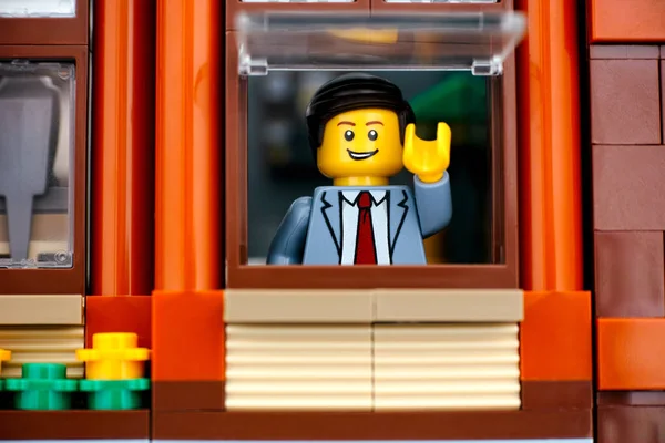 Lego άνθρωπος minifigure στο κοστούμι των επιχειρήσεων κοιτάζοντας έξω από το παράθυρο. — Φωτογραφία Αρχείου
