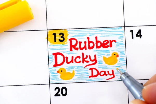 Dedos de mujer con lápiz recordatorio de escritura Rubber Ducky Day en escala —  Fotos de Stock