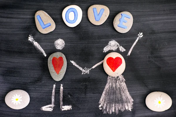 Pebbles with red hearts inside chalk drawing of man and woman an — Stock Photo, Image