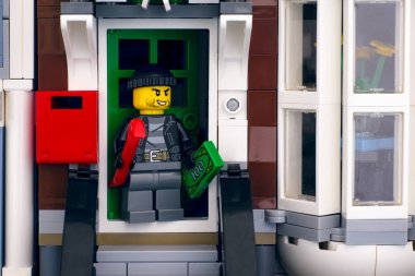 Lego hırsızı minyatür figür, soyulmuş evin kapısında duruyor..