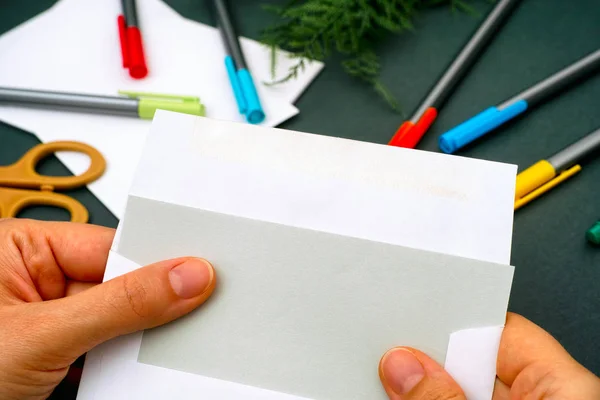 Жінка руки виймає сірий папір з білого конверта . — стокове фото